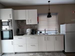 韦拉斯Rosegarden View的厨房配有白色橱柜和白色冰箱。