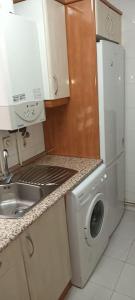 马德里Habitación interior en Madrid的厨房配有洗衣机和水槽