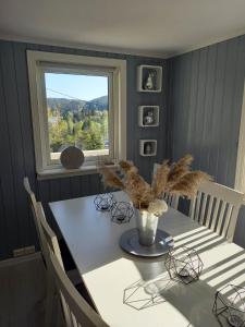 弗洛兰德维尔克Hytte Sørlandet med spa的一间带桌子和窗户的用餐室