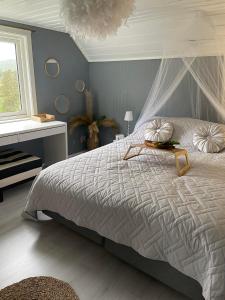 弗洛兰德维尔克Hytte Sørlandet med spa的一间卧室配有一张带天蓬的床