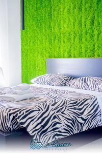 斯卡莱阿La Riviera的卧室里一张斑马印花床,卧室里设有绿色的墙壁