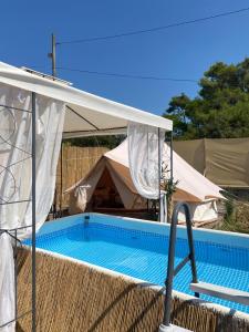 扎达尔Camping Perla的白色天篷帐篷下的游泳池