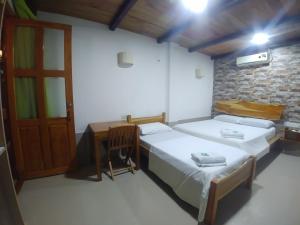 San Juan NepomucenoHotel Malibu的一间卧室配有两张床、一张桌子和一扇门