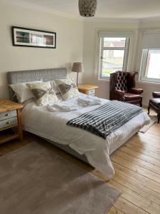 亚历山德里亚Loch Lomond Apartment的一间卧室配有一张床和一把椅子,还有两个窗户
