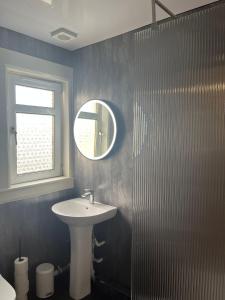 亚历山德里亚Loch Lomond Apartment的一间带水槽和镜子的浴室