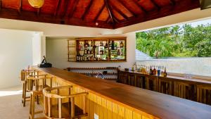 StruieHigh Life Resort & Spa的一个带椅子的酒吧以及一个带瓶子的吧台