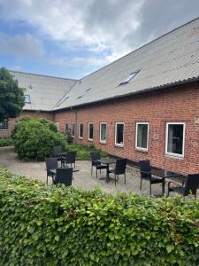 布勒鲁普Assersbølgård的庭院内带桌椅的砖砌建筑