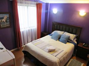 特木科Hostal Remember的一间卧室配有一张蓝色墙壁的床和一扇窗户