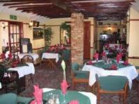 梅斯苔丝三马蹄酒店的餐厅设有桌椅和粉红色的弓