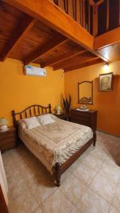 瓜莱瓜伊Casa Quinta La Gualeya的一间卧室配有一张床、两个床头柜和一张四柱床