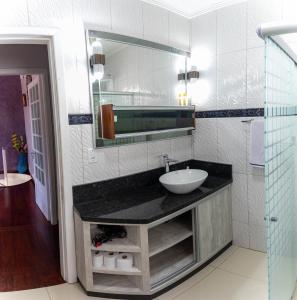 本图贡萨尔维斯Casa confortável e aconchegante的一间带水槽和镜子的浴室
