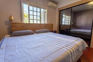 本图贡萨尔维斯Casa confortável e aconchegante的一间卧室设有一张大床和一个大窗户