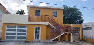 圣胡安Home San Juan的黄色的房子,前面有楼梯