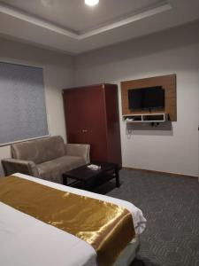 Sīdī Ḩamzahفندق اضواء المدينة的酒店客房配有床、沙发和电视。