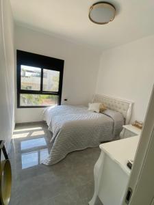 莫迪因best apartment in buhcman (shivtie Israel 26)的白色的卧室设有床和窗户