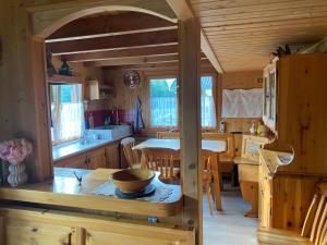 安达洛CHALET JOEN ski & bike Andalo的小屋内的厨房和用餐室配有桌子