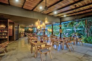 别霍港Namu Garden Hotel & Spa的餐厅设有木桌、椅子和窗户。