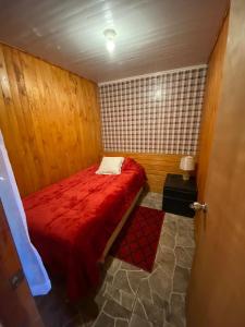 圣地亚哥Hospedaje Pudahuel的一间小卧室,房间内设有一张红色的床
