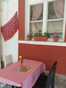 KalnaEtno Konak Angela的一张桌子,上面有红白的格子布和窗户