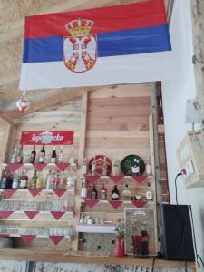 KalnaEtno Konak Angela的悬挂在酒吧上方的旗帜,上面装有酒瓶