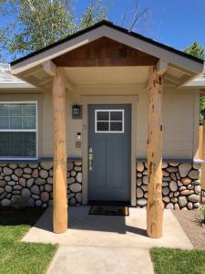 格兰茨帕斯Riverside Cabin 3的一座带蓝色门和石墙的房子