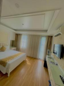 下龙湾Bài Thơ Mountain Hotel的一间卧室配有一张床和一台电视