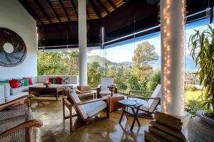 康提玛杜可茶园生态旅馆的客厅设有大窗户和家具。