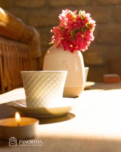 曼克拉Panorama garden inn的花瓶,坐在桌子上,放着蜡烛