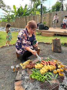 邦美蜀Tam An Lakeview House的女人在烧烤架上做饭