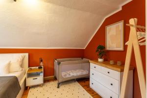 柯尼希施泰因易北Moderne Ferienwohnung mit Festungsblick im Zentrum的一间卧室拥有橙色的墙壁,配有一张床和一个梳妆台