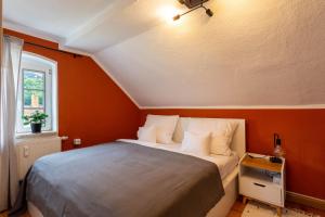 柯尼希施泰因易北Moderne Ferienwohnung mit Festungsblick im Zentrum的一间卧室配有一张橙色墙壁的床