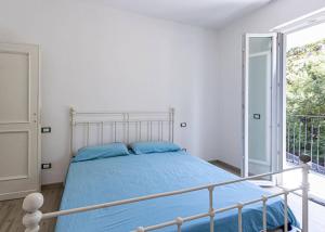 马尔恰纳Gelso的一间卧室配有一张蓝色床单和一个阳台。