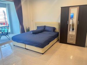 Ban Thung ThongAB House的一间卧室配有一张带蓝色床单的床和梳妆台。