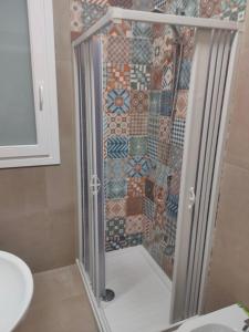 马尔萨拉La casetta della Pigna Verde的浴室设有淋浴,墙上铺有马赛克瓷砖。