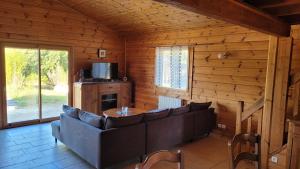 Saint-BriceChalet avec baignade écologique的小木屋内带沙发的客厅