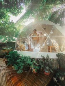 道因Glamping Dome Dauin Beach Resort的站在草棚里的人