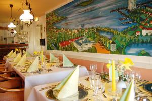 石勒苏益格霍亨索伦酒店的餐厅的一排桌子,上面有绘画