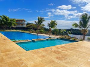特里罗杰Cozy one bedroom apartment in a secure complex , PORT CHAMBLY Mauritius的一座棕榈树游泳池和一座房子