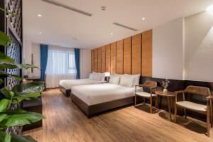 岘港Señorita Boutique Hotel的酒店客房带一张床、一张桌子和椅子