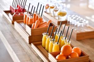 利雅德Riyadh Diplomatic Quarter - Marriott Executive Apartments的自助餐,包括胡萝卜、橘子和木容器中的果汁