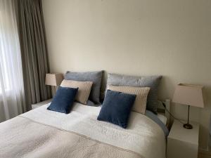 巴勒哈姆斯泰德Lonestar Appartement的一间卧室配有一张带蓝色枕头的大床