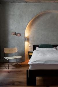 阿尔代兹Ein Kraftort und architektonisches Juwel的一间卧室配有一张床和一把椅子