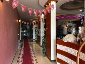 哈伊勒رسلين للشقق المخدومة的走廊上设有粉红色的墙壁和红色的地毯
