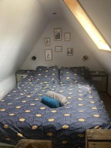 阿罗La « cabaneste » dans Arreau的阁楼上一张带蓝色和黄色棉被的床