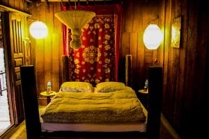 奇旺Shanta Ghar A Rustic Guesthouse的一间卧室配有一张带两盏灯的床。