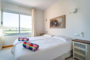 马斯帕洛马斯Villa Vista Golf Salobre - Maspalomas self-sufficient with pool heating的一间卧室设有两张床和窗户。