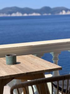 阿索斯卡纳基斯公寓酒店的坐在阳台上木桌旁的咖啡杯