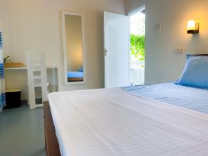 韦利格默海湾屋旅馆的卧室设有一张白色大床和一扇窗户。