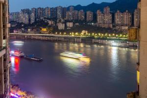 重庆重庆早安醉美江景民宿的河上有建筑物,晚上有城市