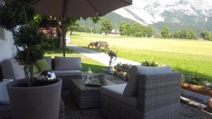 拉姆绍达赫斯坦Bergführerhaus的庭院设有椅子、遮阳伞和马匹。